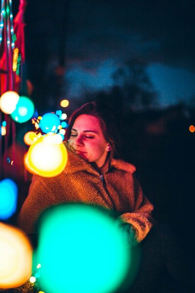 Tulsa Christmas Lights - A woman sitting on a bench in front of lights.